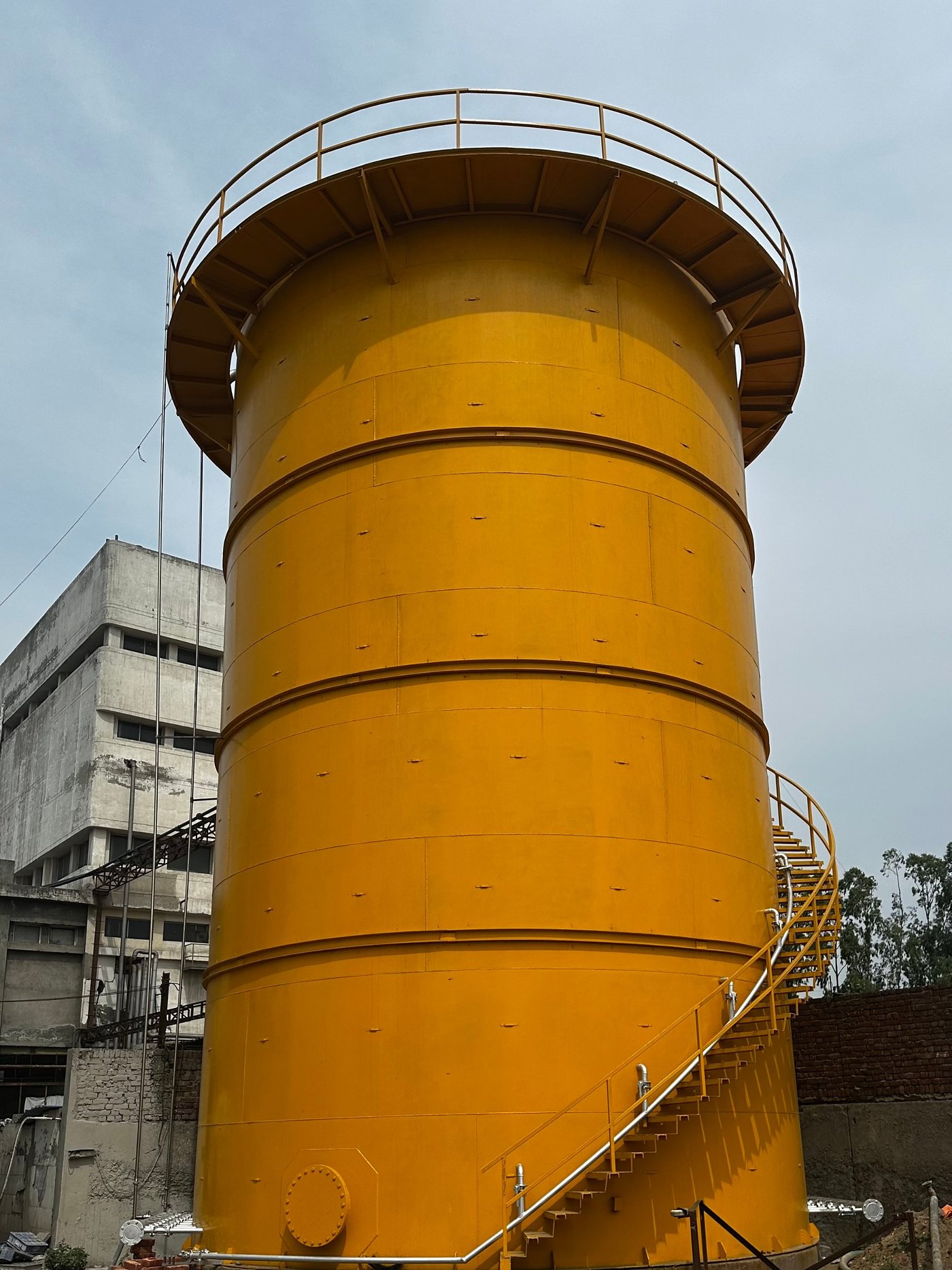 Yellow UASB reactor with top platform and spiral staircase